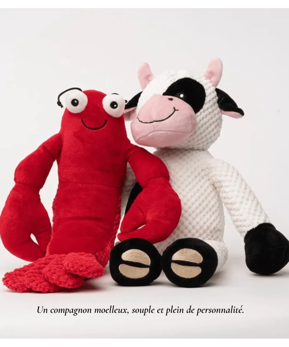Peluche homard rouge à côté d’une peluche vache blanche et noire, pour chien