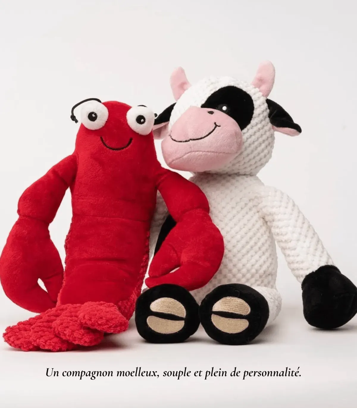 Peluche homard rouge à côté d’une peluche vache blanche et noire, pour chien