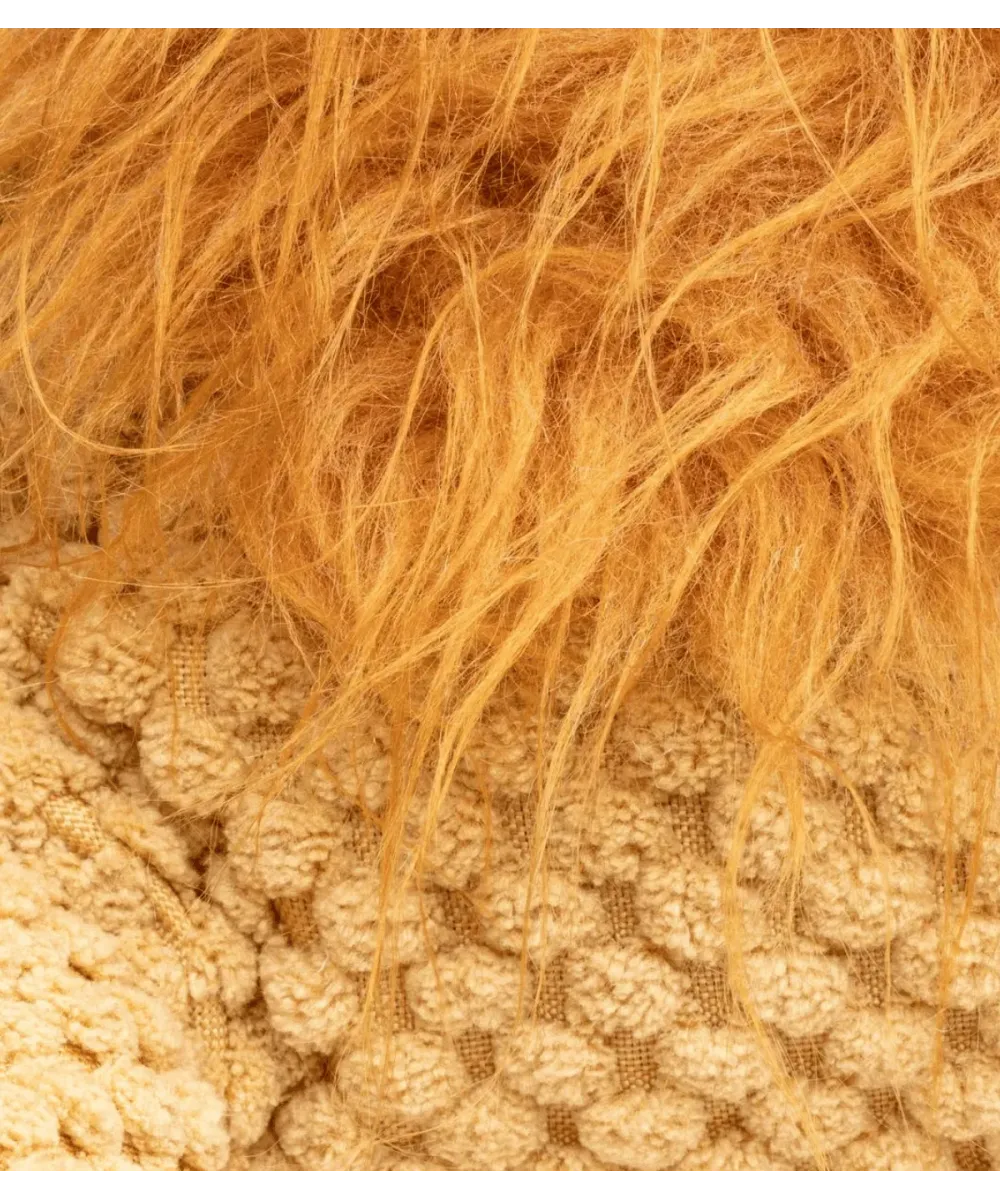 Gros plan sur la crinière orange et le tricot gaufré de la peluche lion