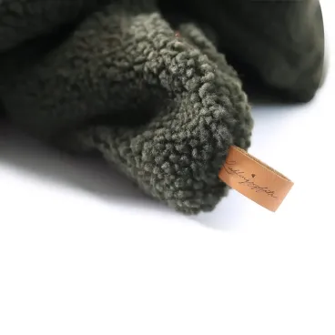 Détail de la finition du tissu et de la marque en cuir de la gigoteuse Cocoon pour chien